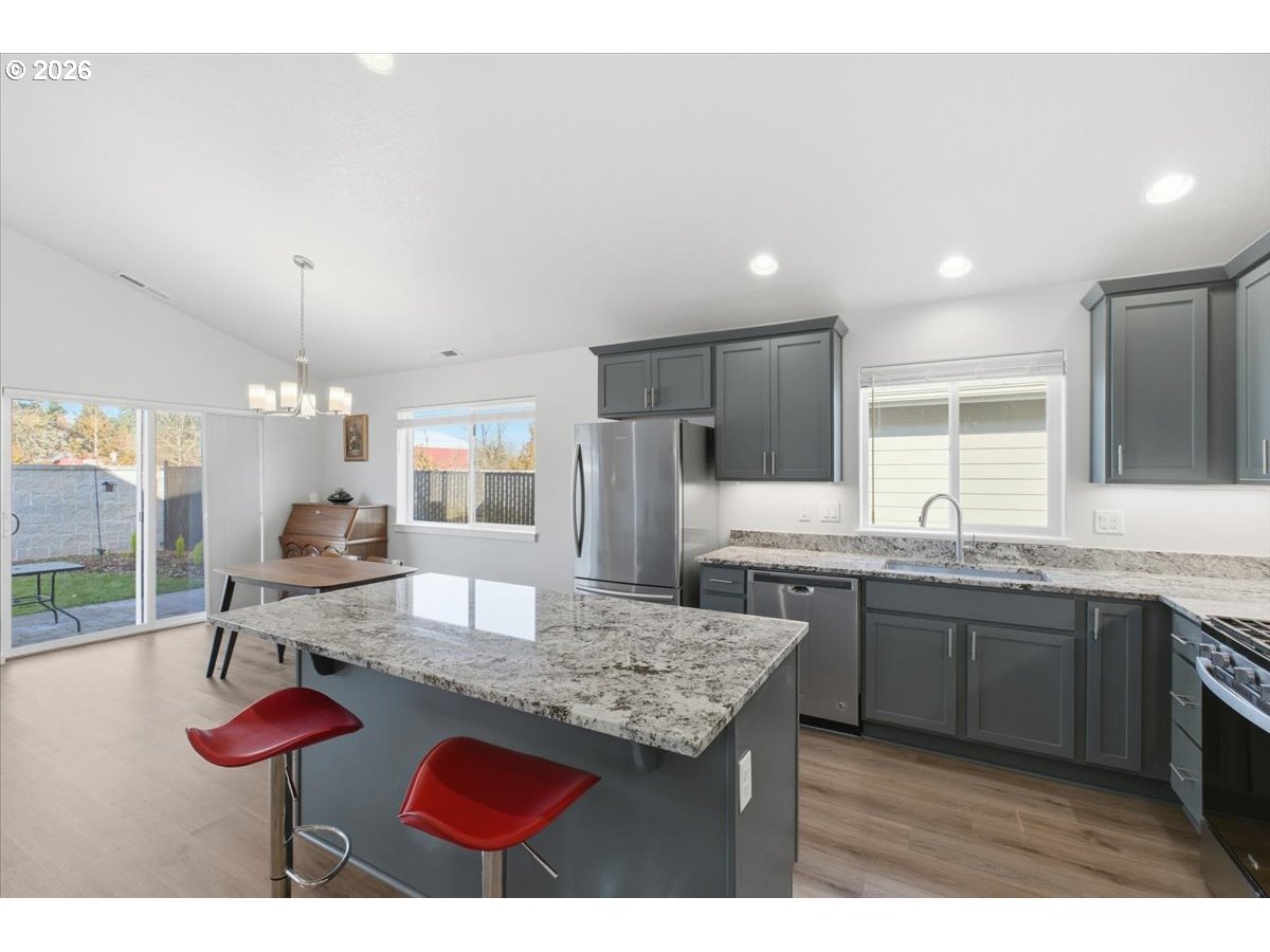 2046 Southeast Academy Street Dallas, OR 97338 - Photo 12 of 47 a kitchen with kitchen island stainless steel appliances a sink and cabinets