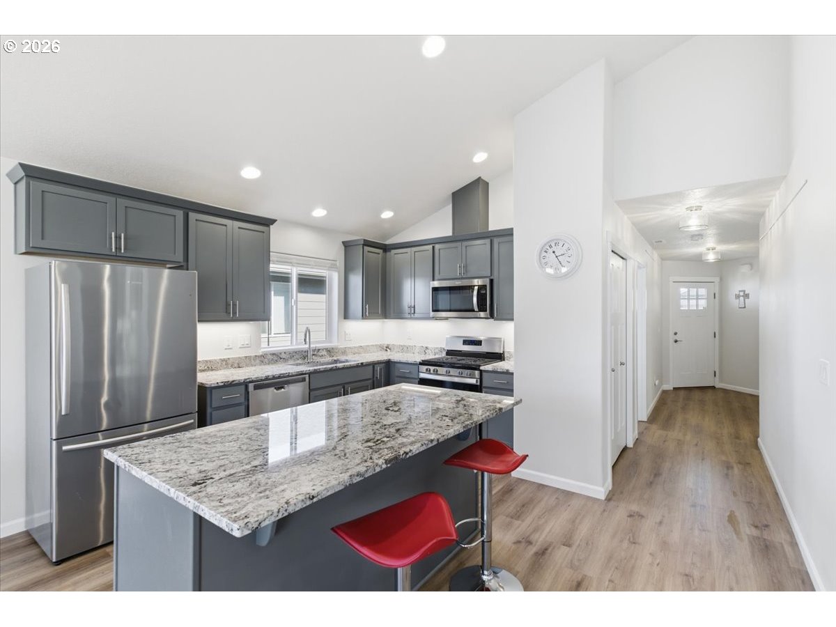 2046 Southeast Academy Street Dallas, OR 97338 - Photo 13 of 47 a kitchen with stainless steel appliances granite countertop a refrigerator a stove and a sink with wooden floor