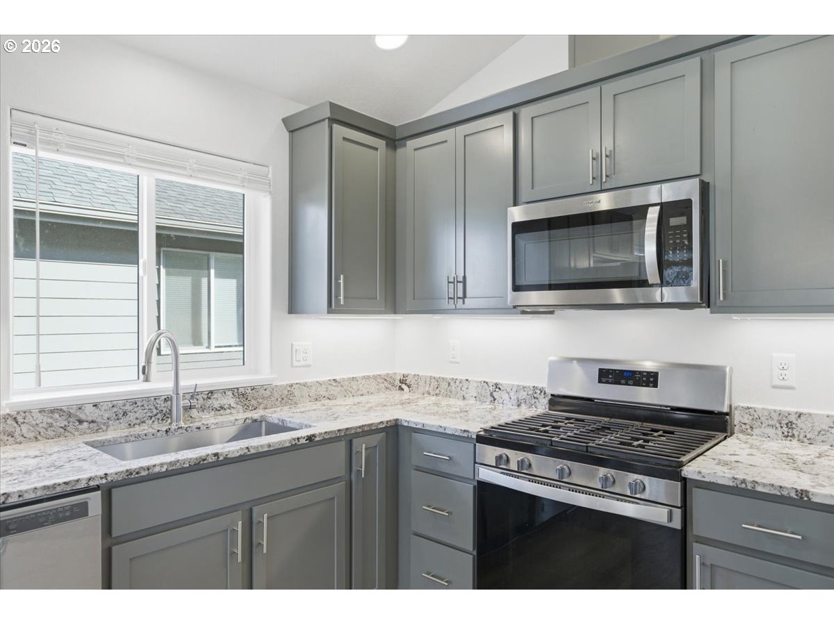 2046 Southeast Academy Street Dallas, OR 97338 - Photo 16 of 47 a kitchen with granite countertop a sink stove and microwave
