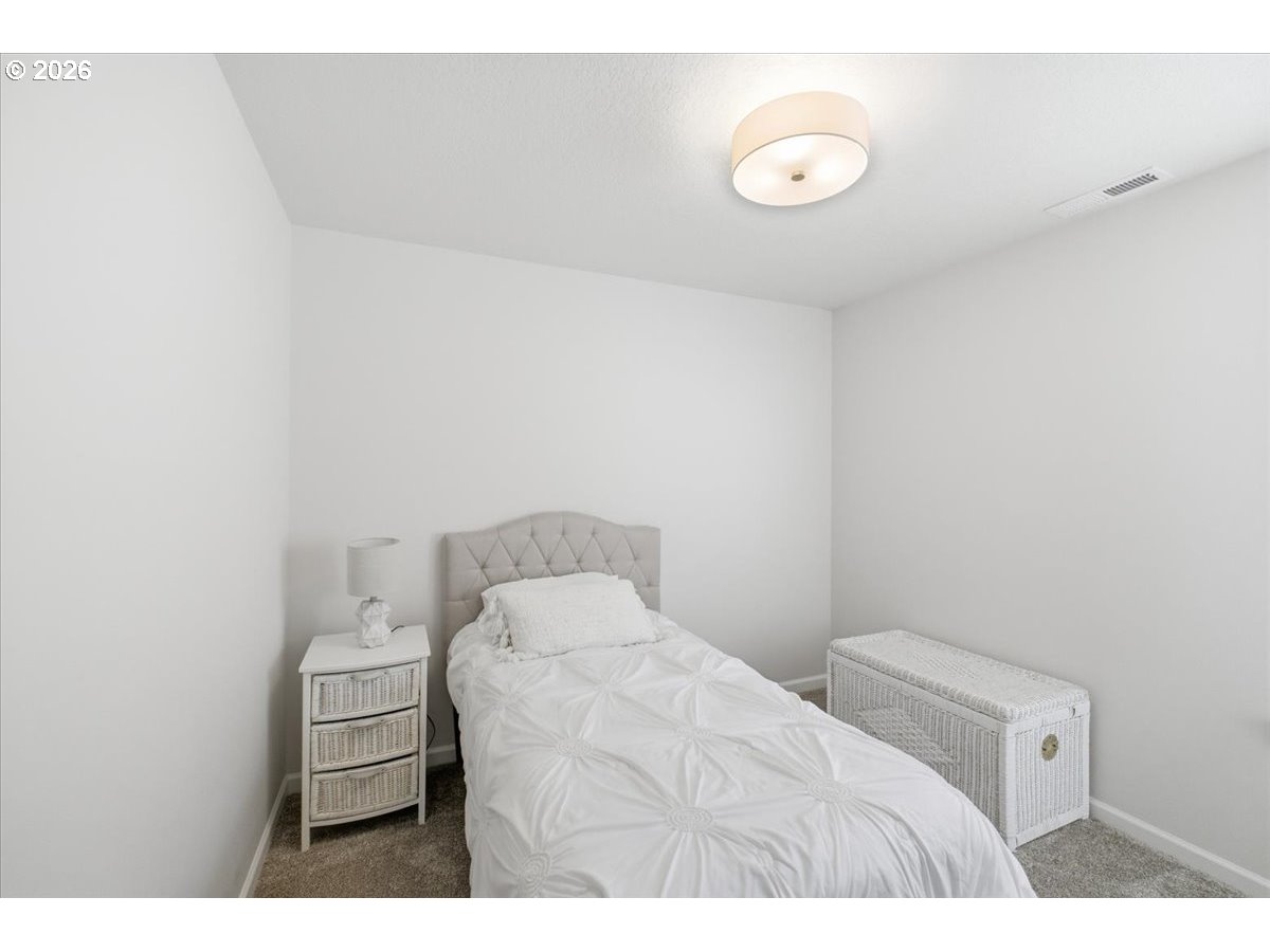 2046 Southeast Academy Street Dallas, OR 97338 - Photo 29 of 47 a bedroom with a bed and a lamp