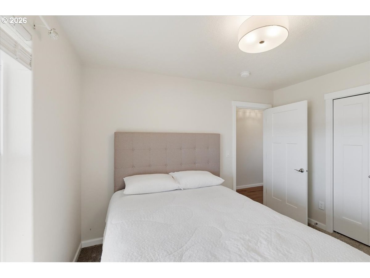 2046 Southeast Academy Street Dallas, OR 97338 - Photo 32 of 47 a bedroom with a bed and a lamp