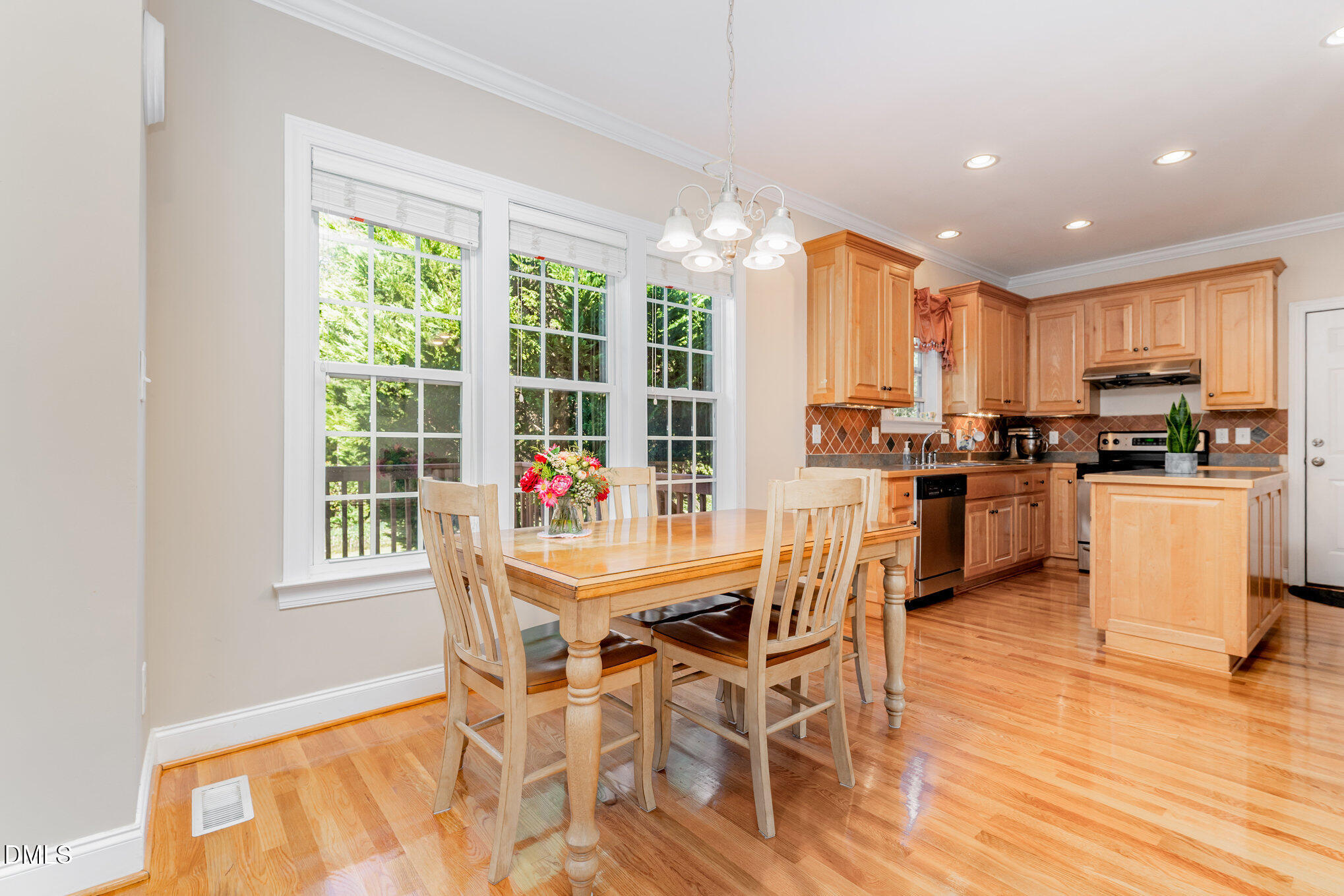 272 Travel Lite Drive Raleigh, NC 27603 - Photo 6 of 30 a dining room with stainless steel appliances furniture large window and wooden floor