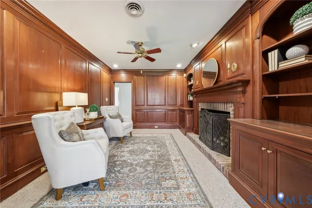 a living room with furniture a fireplace and a large window