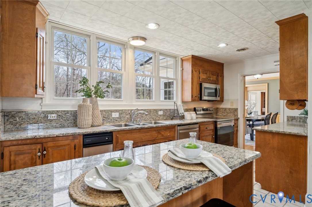4411 Courthouse Road Prince George, VA 23875 - Photo 3 of 38 a large kitchen with granite countertop a stove a sink a dining table and chairs