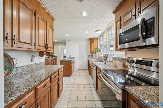 a kitchen with stainless steel appliances granite countertop a stove a sink and a microwave