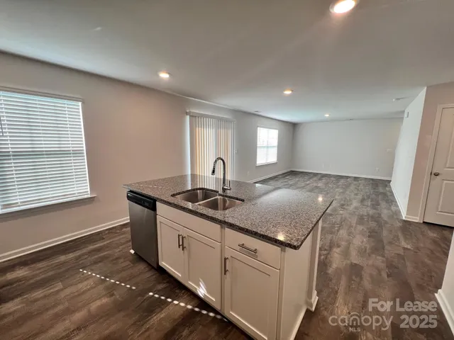 a kitchen with granite countertop a sink and a stove
