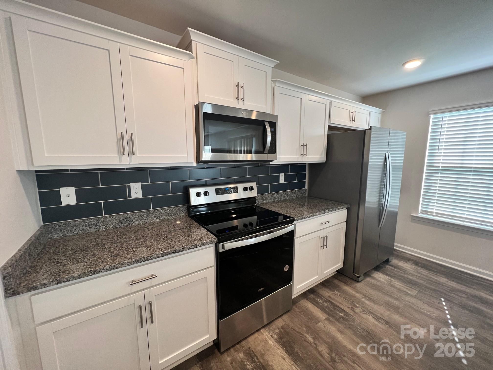 7868 Whispering Stream Drive Sherrills Ford, NC 28673 - Photo 10 of 35 a kitchen with stainless steel appliances granite countertop a stove a sink and a microwave