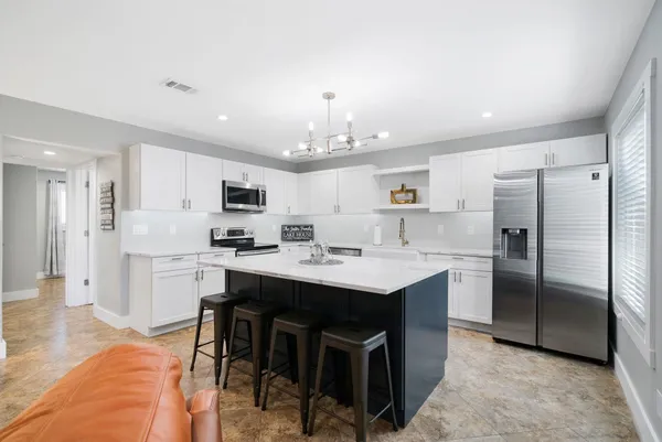 a kitchen with kitchen island a sink stove and refrigerator