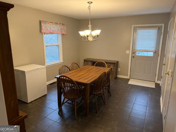 a view of a dining room with furniture and a chandelier