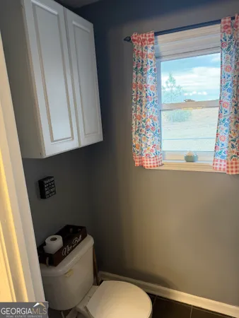 a white toilet sitting next to a window
