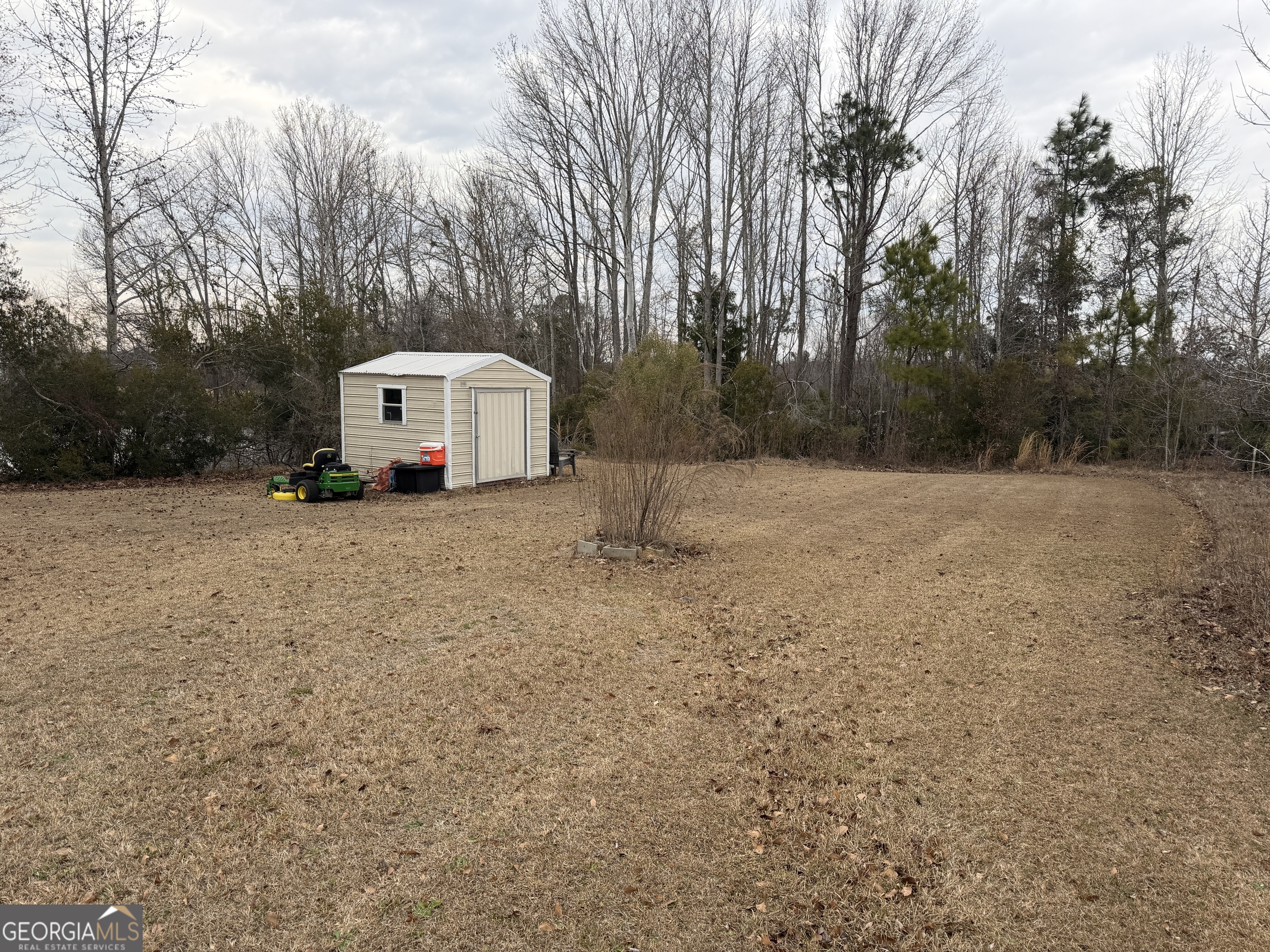 141 Evergreen Church Road Cobbtown, GA 30420 - Photo 25 of 29 a white house with a large tree next to a yard