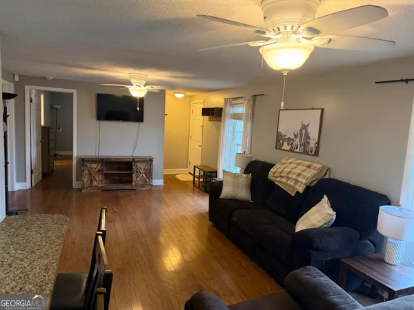 a living room with furniture or chandelier and a wooden floor
