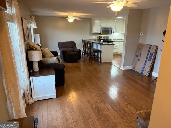 a living room with furniture and a wooden floor