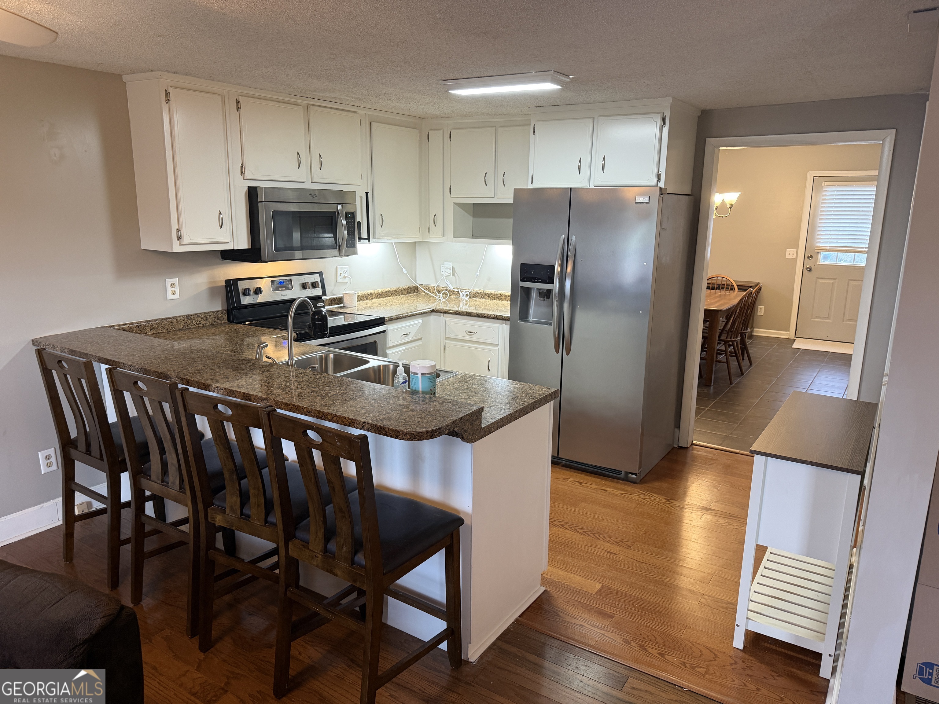 141 Evergreen Church Road Cobbtown, GA 30420 - Photo 6 of 29 a kitchen with stainless steel appliances granite countertop a dining table chairs refrigerator and sink