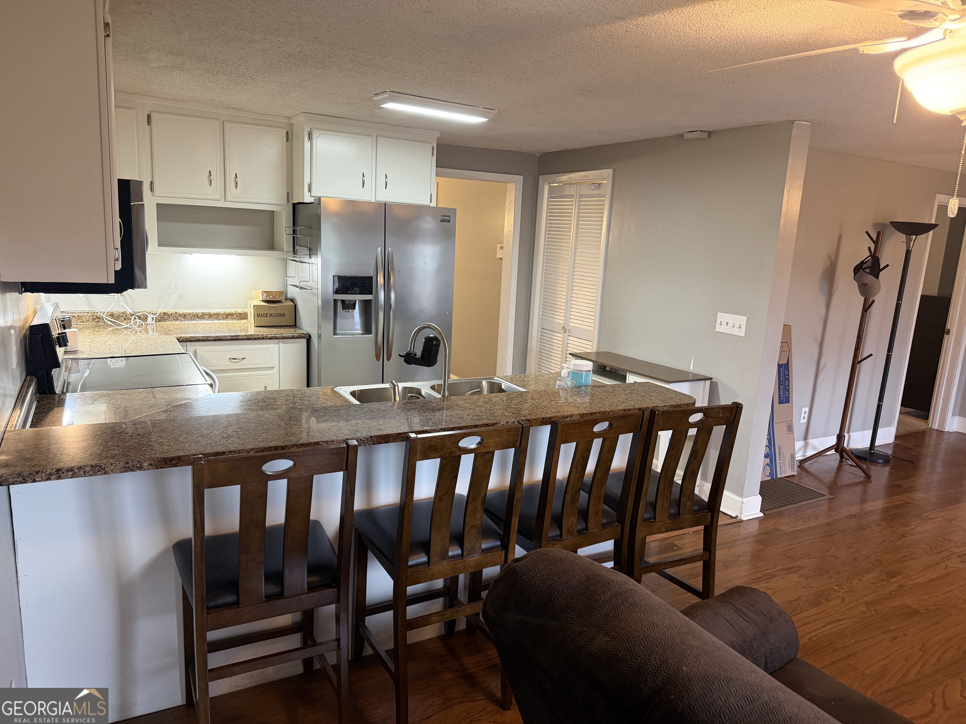 141 Evergreen Church Road Cobbtown, GA 30420 - Photo 7 of 29 a kitchen with granite countertop a dining table chairs cabinets and stainless steel appliances