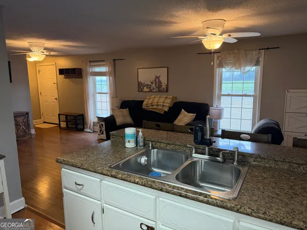 a kitchen with granite countertop a sink a stove and cabinets
