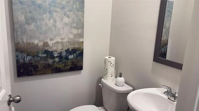 a white toilet sitting next to a bathroom sink