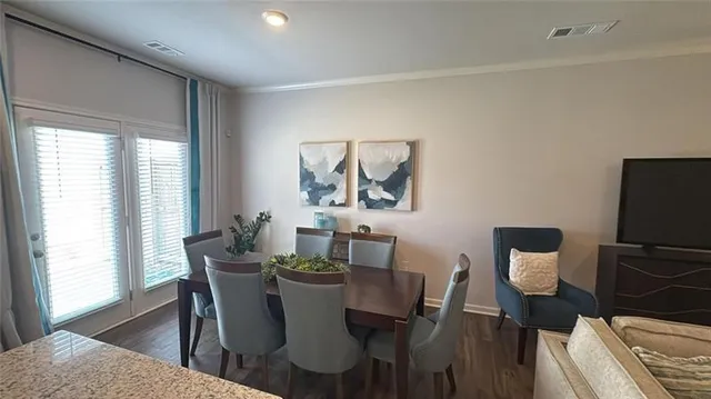 a view of a dining room with furniture a rug and wooden floor