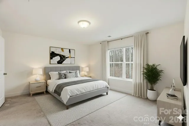 a bedroom with a large bed and a potted plant