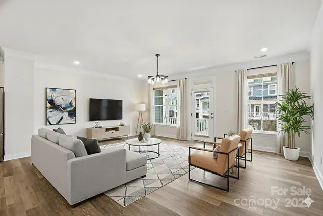 a living room with furniture a flat screen tv and a large window