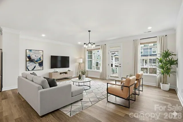 a living room with furniture a flat screen tv and a large window