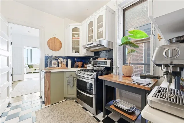 a kitchen with stainless steel appliances granite countertop a stove a sink and a microwave