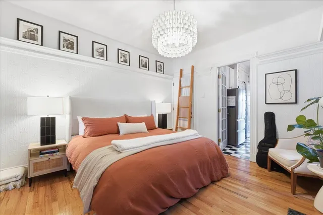a bedroom with bed and a chandelier