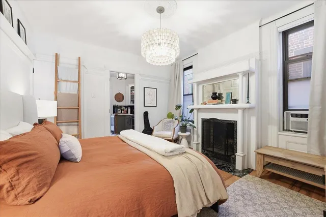 a bedroom with a large bed and a fireplace