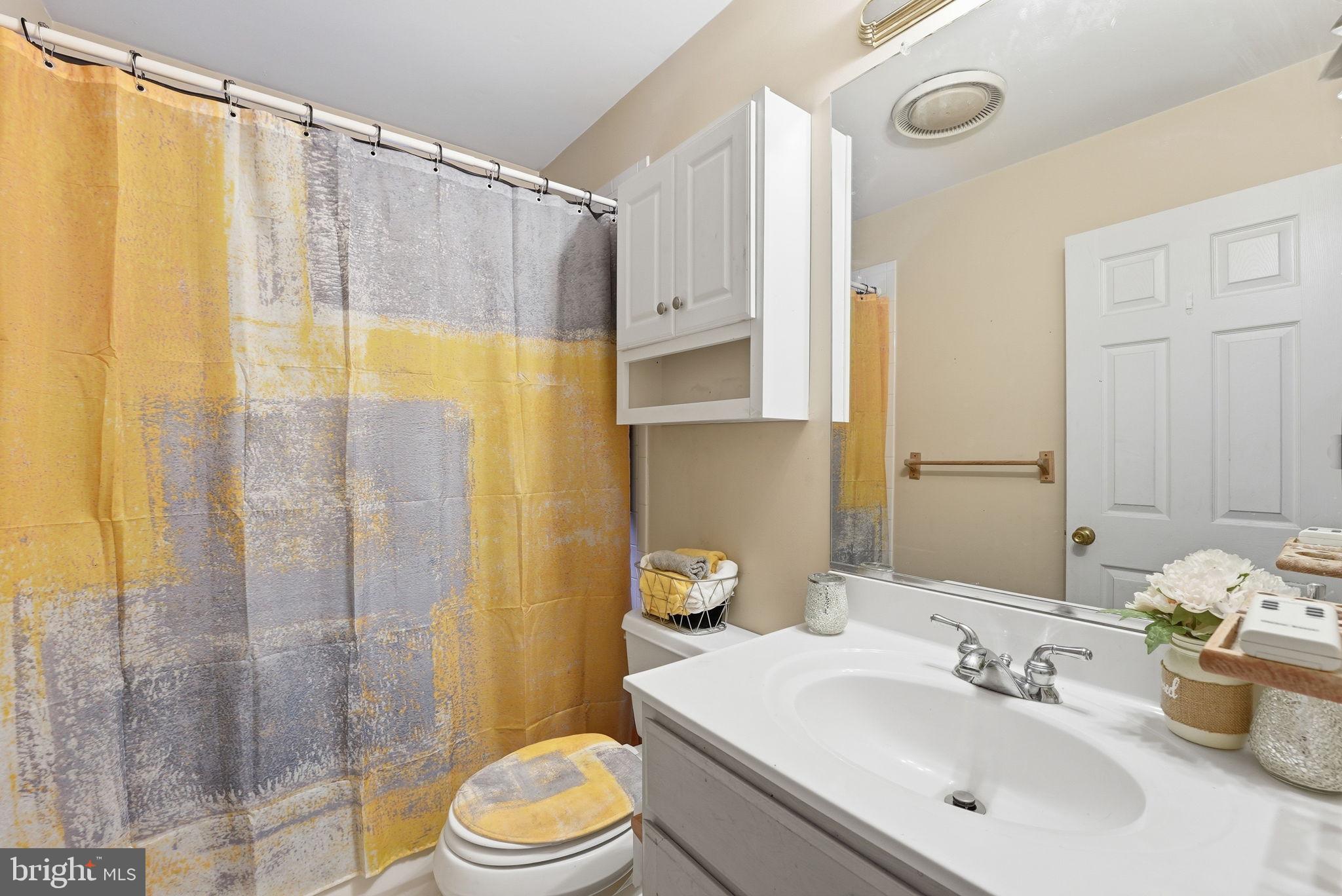 6870 Hawkins Gate Road La Plata, MD 20646 - Photo 16 of 24 a bathroom with a sink a toilet and shower curtain