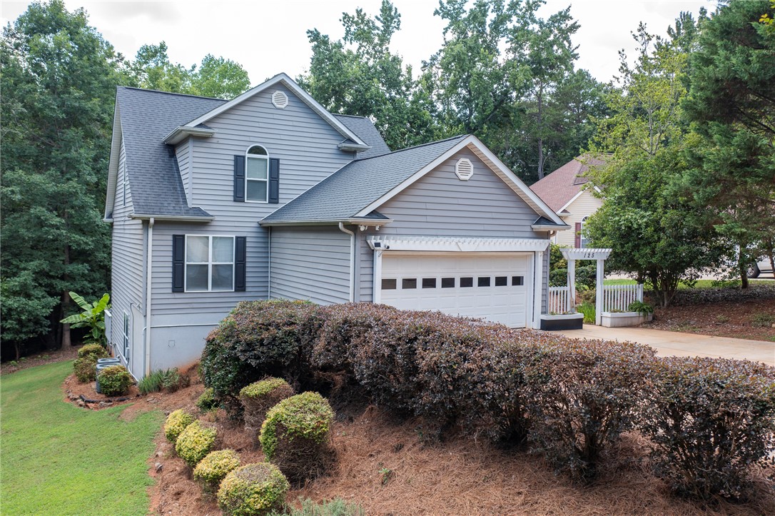 125 Inlet Pointe Drive Anderson, SC 29625 - Photo 1 of 39 A welcoming abode nestled amongst mature trees, featuring a prominent two-car garage and manicured landscaping.