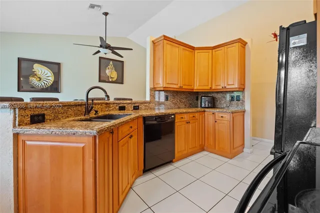a kitchen with stainless steel appliances granite countertop a sink and a refrigerator