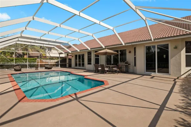 a view of a patio with a table and chairs under an umbrella