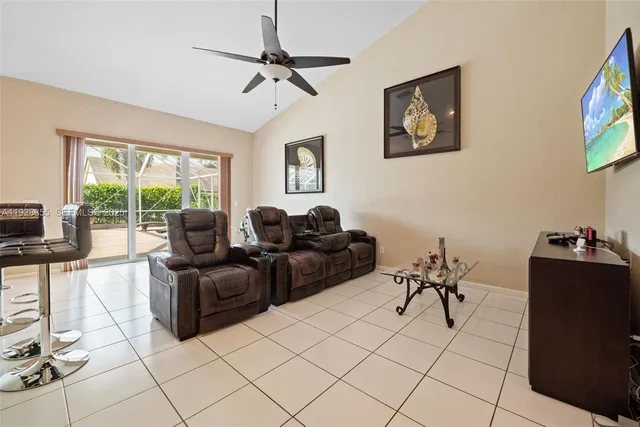 a living room with furniture a flat screen tv and a window