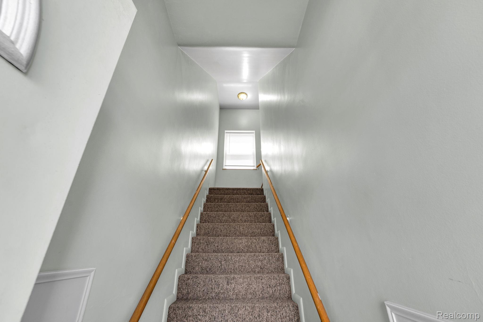 5223 Allen Road Allen Park, MI 48101 - Photo 4 of 12 Carpeted staircase with light-colored walls and a wood handrail