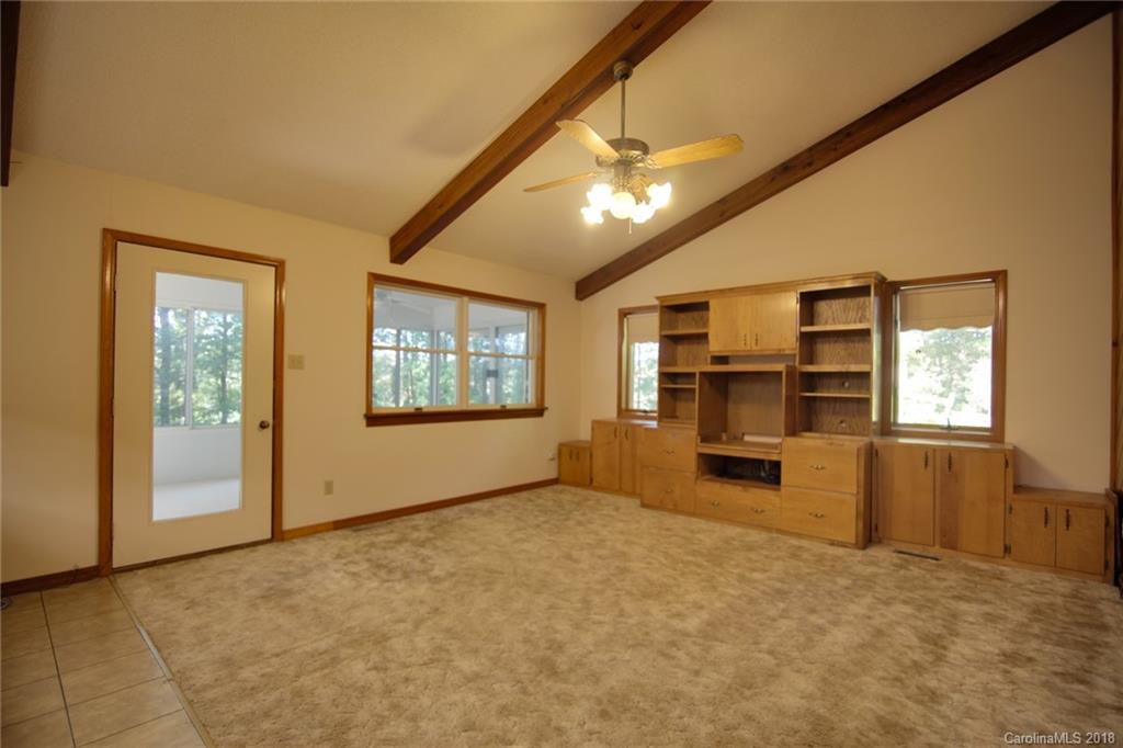 503 Jim Dobbins Road Rutherfordton, NC 28139 - Photo 16 of 34 an empty room with windows chandelier and fireplace
