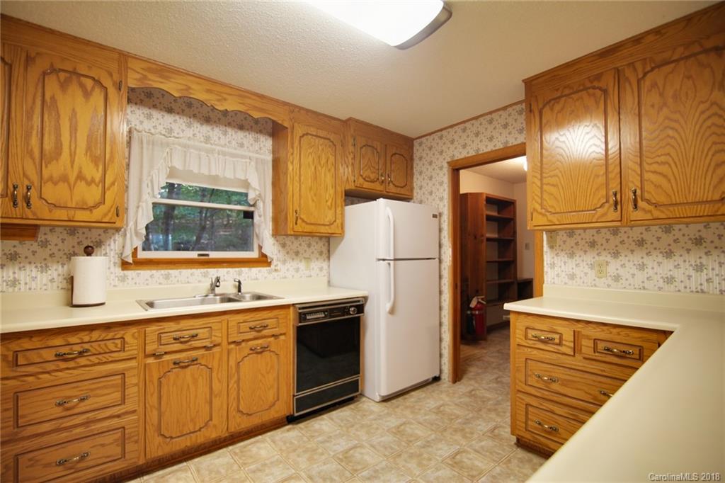503 Jim Dobbins Road Rutherfordton, NC 28139 - Photo 6 of 34 a kitchen with a sink a refrigerator and cabinets