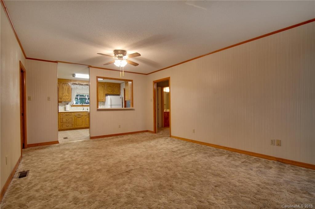 503 Jim Dobbins Road Rutherfordton, NC 28139 - Photo 9 of 34 an empty room with chandelier fan and windows