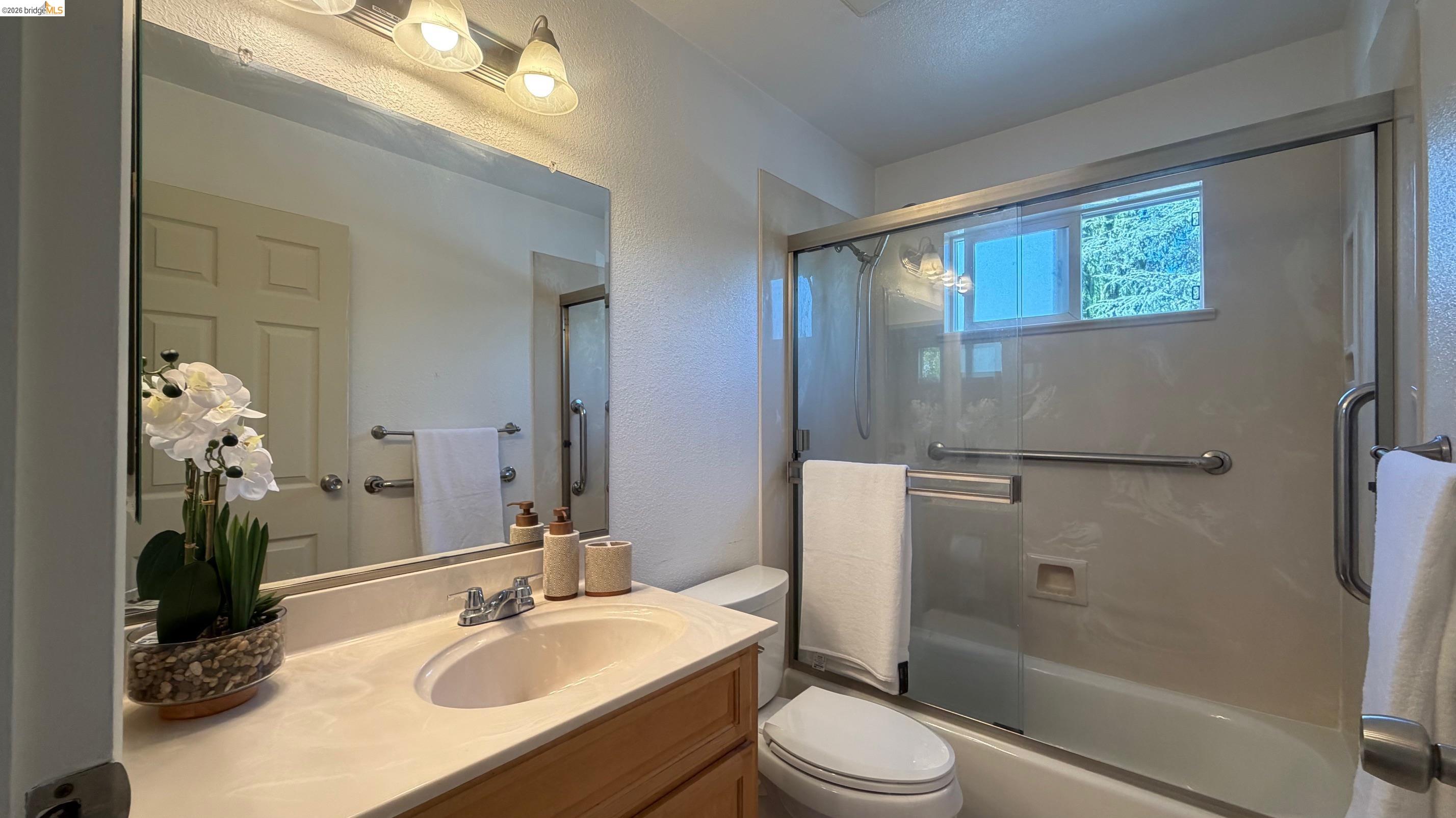 9085 Alcosta Boulevard, Unit 331 San Ramon, CA 94583 - Photo 14 of 18 Bathroom with a textured wall, vanity, and bath / shower combo with glass door