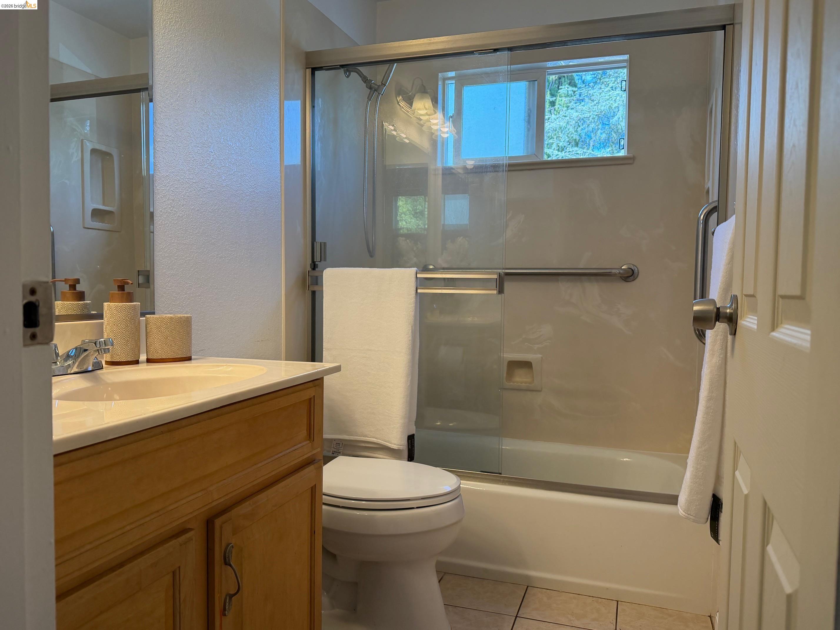 9085 Alcosta Boulevard, Unit 331 San Ramon, CA 94583 - Photo 15 of 18 Bathroom with vanity, a textured wall, light tile patterned floors, and shower / bath combination with glass door