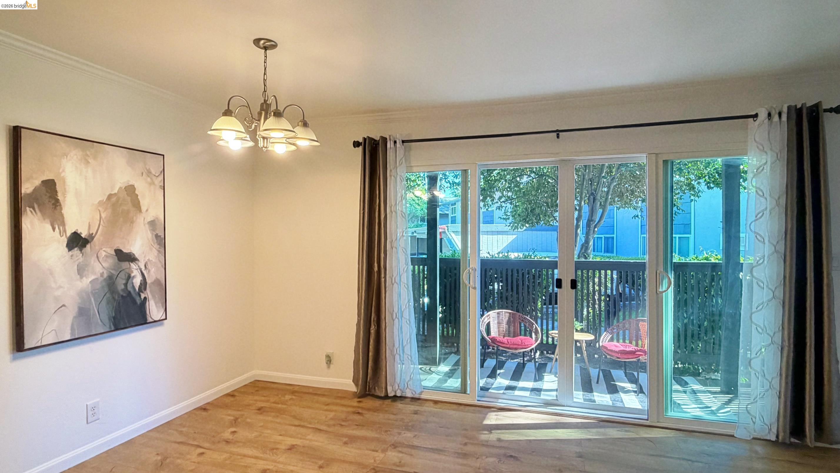 9085 Alcosta Boulevard, Unit 331 San Ramon, CA 94583 - Photo 7 of 18 Unfurnished room with light wood-style flooring, hanging lights, and ornamental molding