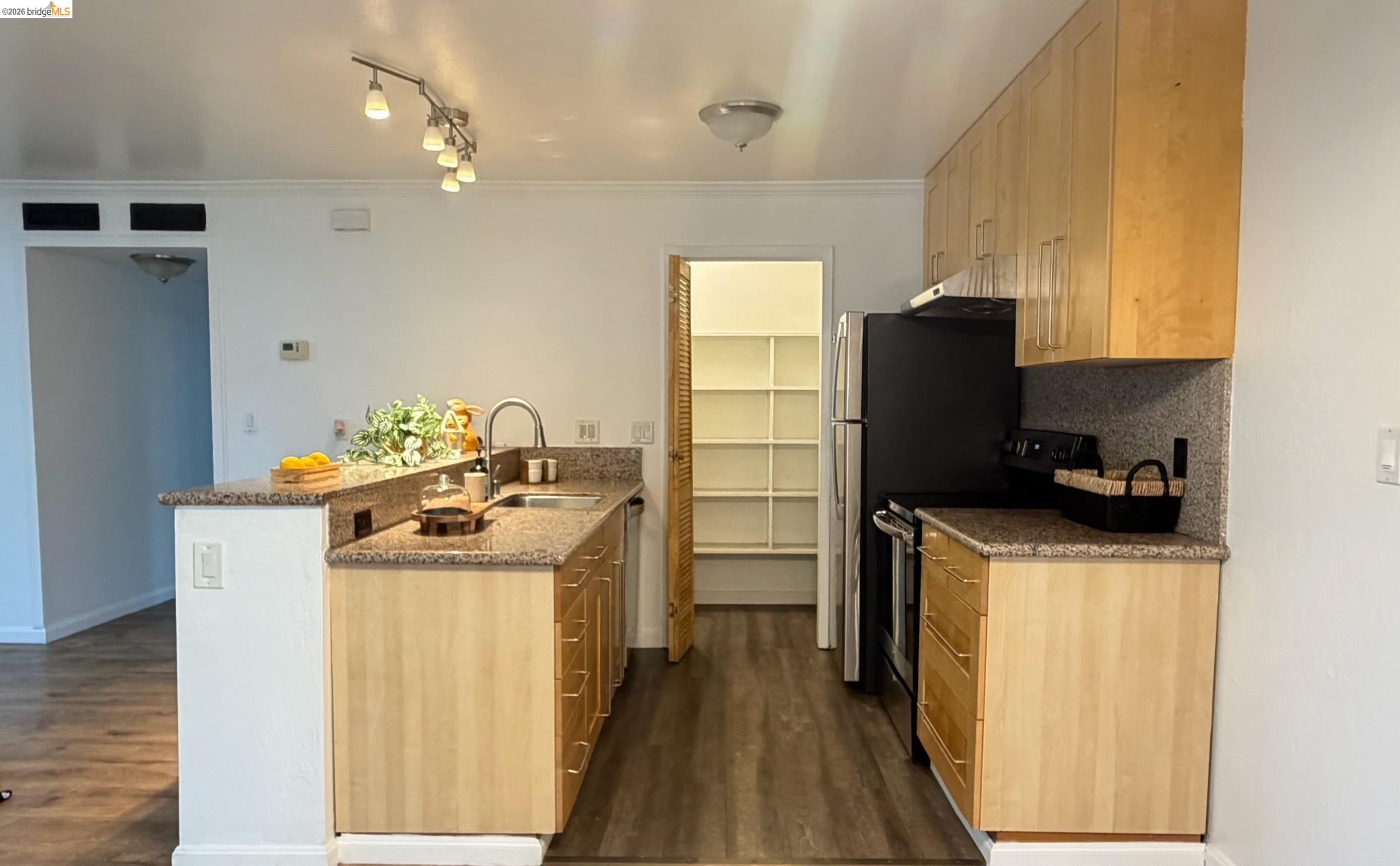 9085 Alcosta Boulevard, Unit 331 San Ramon, CA 94583 - Photo 9 of 18 Kitchen featuring light wood finish cabinetry, a peninsula, stainless steel appliances, decorative backsplash, and crown molding