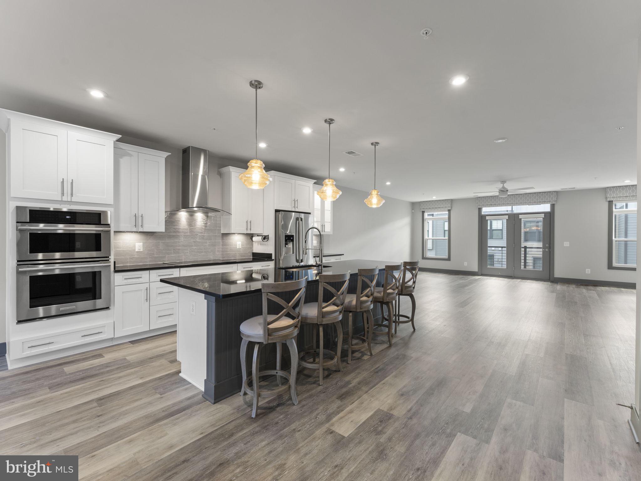 1616 Bandit Loop, Unit 10B Reston, VA 20190 - Photo 8 of 24 a kitchen with stainless steel appliances a dining table chairs stove and cabinets