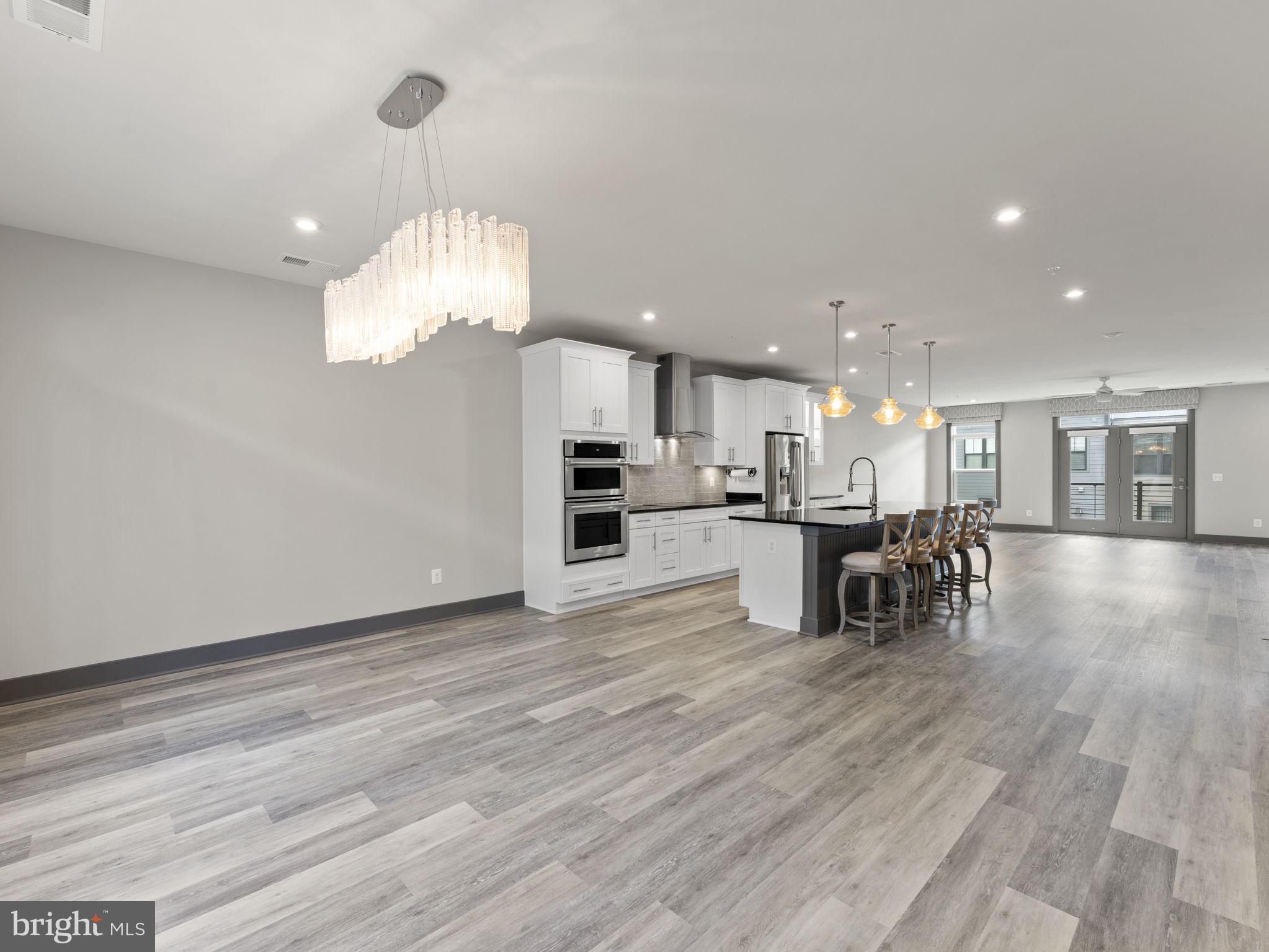 1616 Bandit Loop, Unit 10B Reston, VA 20190 - Photo 9 of 24 a kitchen with stainless steel appliances granite countertop a refrigerator oven a stove a dining table and chairs with wooden floor