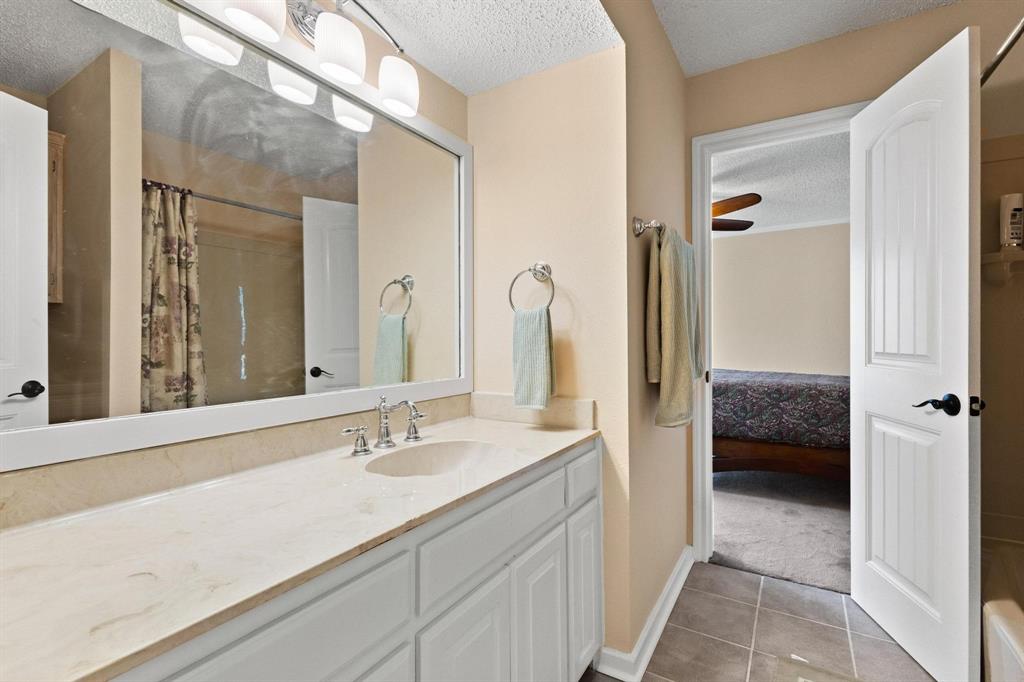 455 Lakepoint Loop Pottsboro, TX 75076 - Photo 12 of 36 Bathroom with a textured ceiling, ensuite bath, light tile patterned floors, vanity, and curtained shower