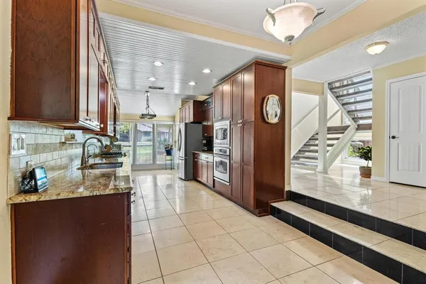 a kitchen with stainless steel appliances granite countertop a refrigerator and a stove