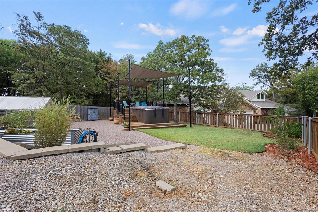 455 Lakepoint Loop Pottsboro, TX 75076 - Photo 30 of 36 Fenced backyard with a Swim Spa, a wooden deck, a greenhouse, and an outbuilding