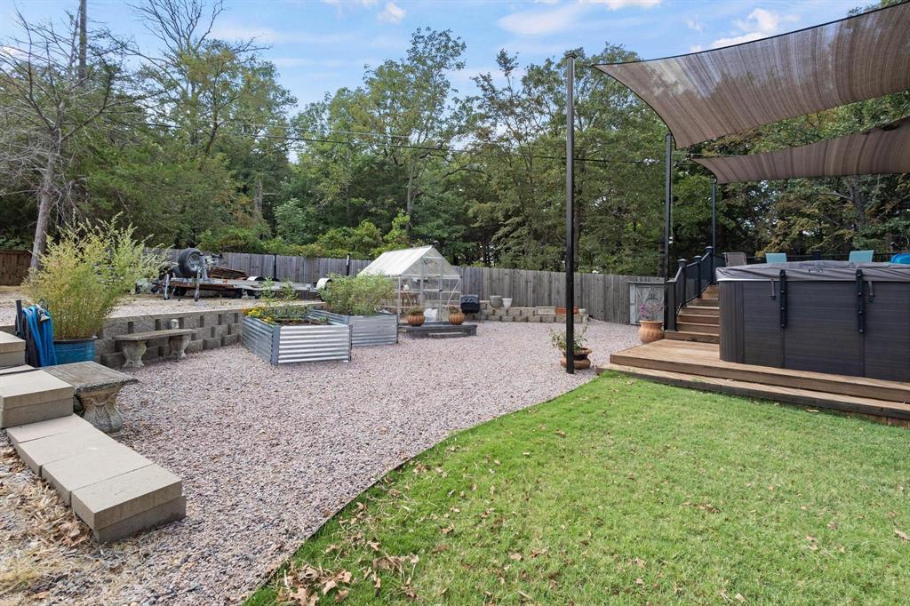 455 Lakepoint Loop Pottsboro, TX 75076 - Photo 31 of 36 Fenced backyard featuring a deck, an exterior structure, an outbuilding, and a vegetable garden