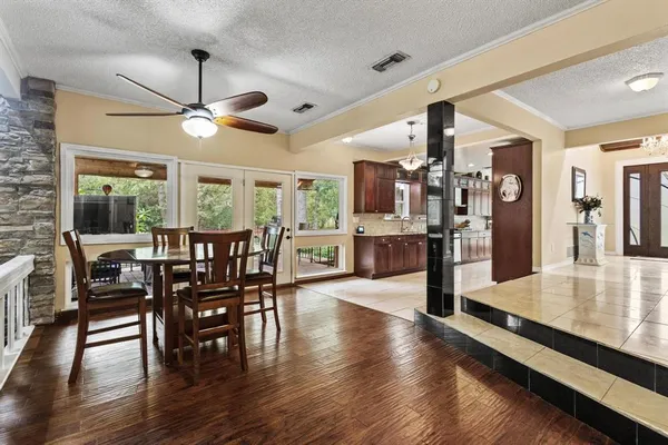a view of a dining room and livingroom with furniture wooden floor a rug a flat screen tv