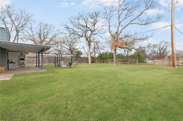 a view of a house with backyard and a tree