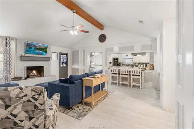 a living room with furniture a fireplace and a ceiling fan